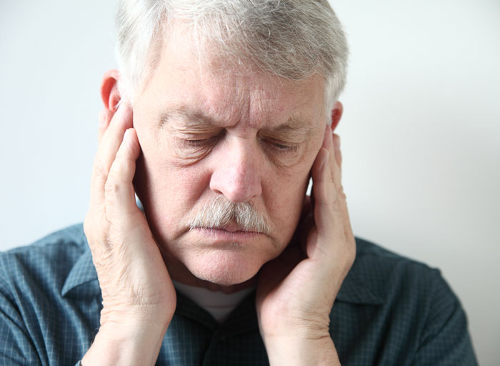 Photo of an older man, head bowed with jawbone pain