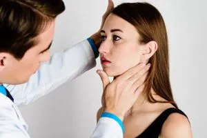 Woman getting assessed for corrective jaw surgery by an oral surgeon in a dental office